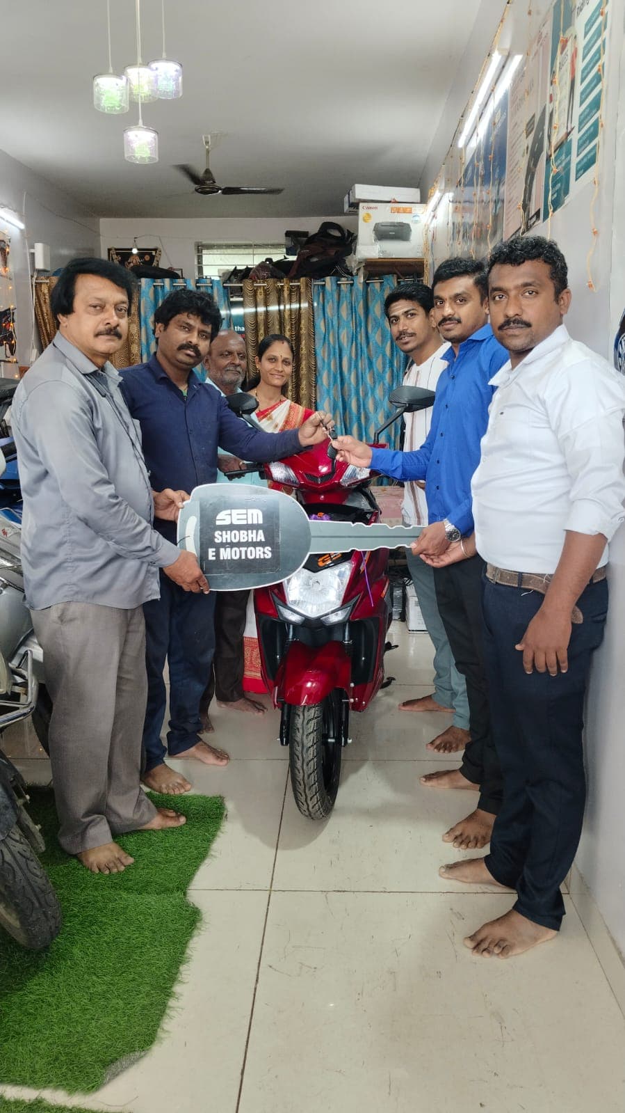Happy customer receiving electric scooter keys at Shobha E Motors