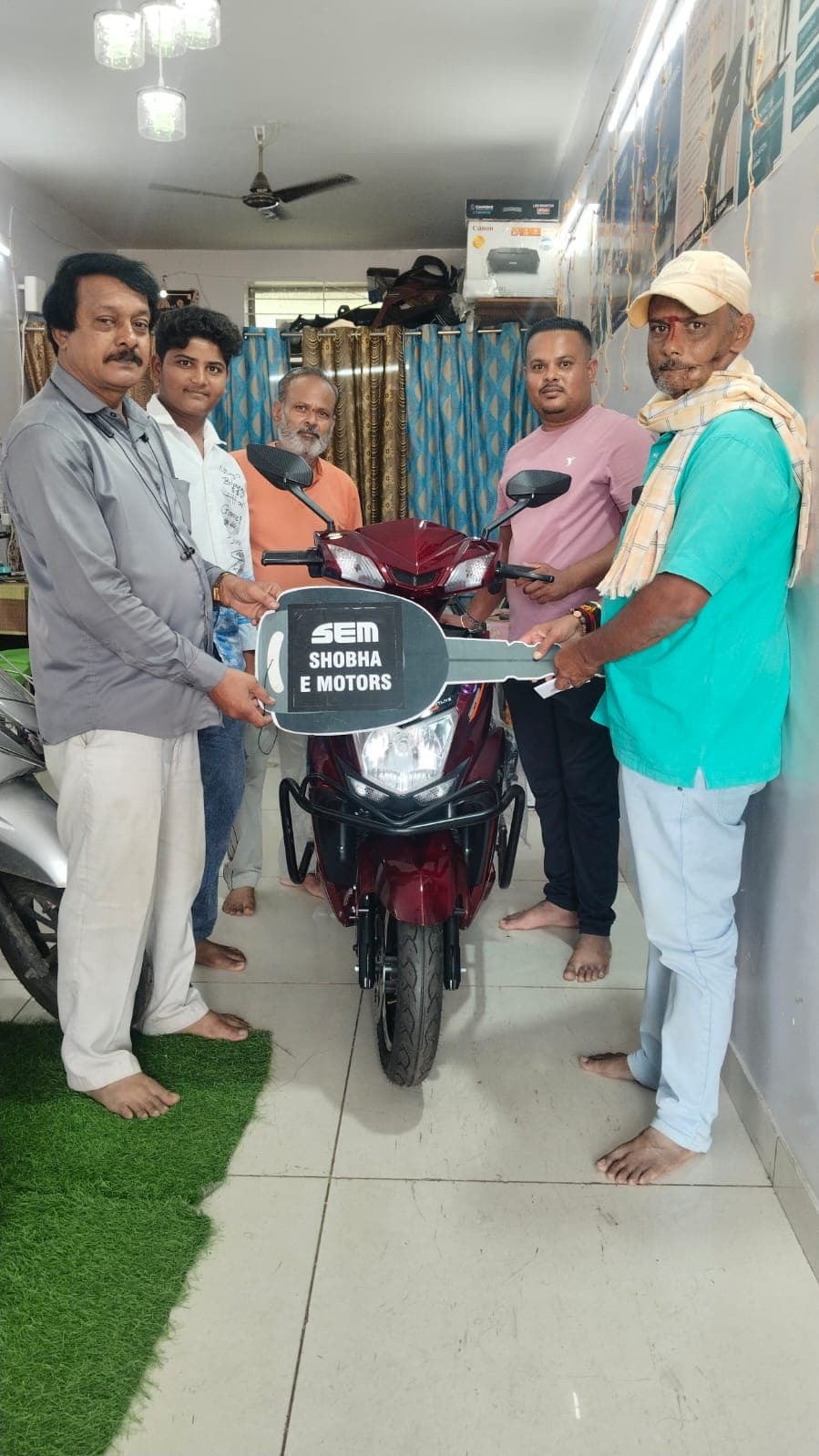 Customer delivery of red electric scooter at Shobha E Motors
